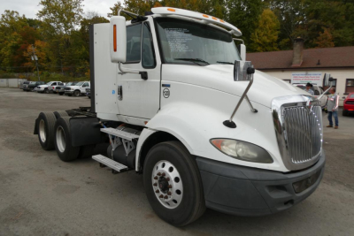 White 2013 International PROSTAR+ 113 conventional daycab truck from the front-right side. Visible text on windshield and door window stickers.