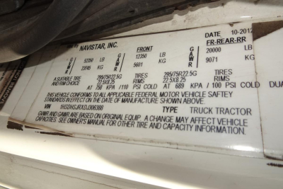Truck cab door placard with vehicle specs including Navistar INC. data, date, front and rear axle ratings, tires, and GVWR; VIN 1HSDHSJRXDJ306388; stock info visible.