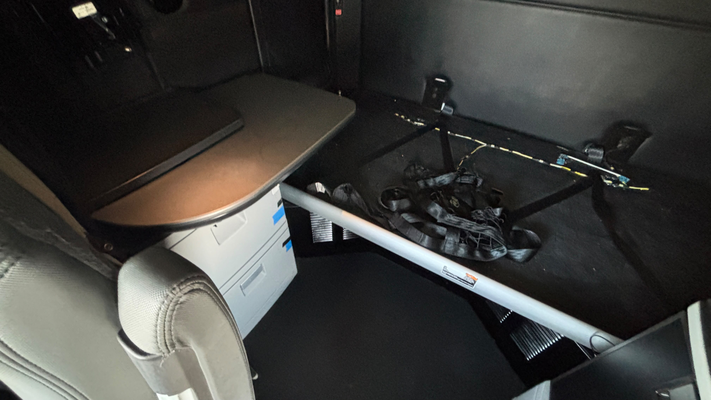 Kenworth T680 sleeper truck interior showing dashboard and under-seat storage with metal rod across cabin.