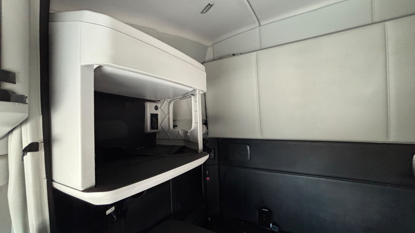Kenworth T680 sleeper cab interior showing a microwave mounted inside the cabin.
