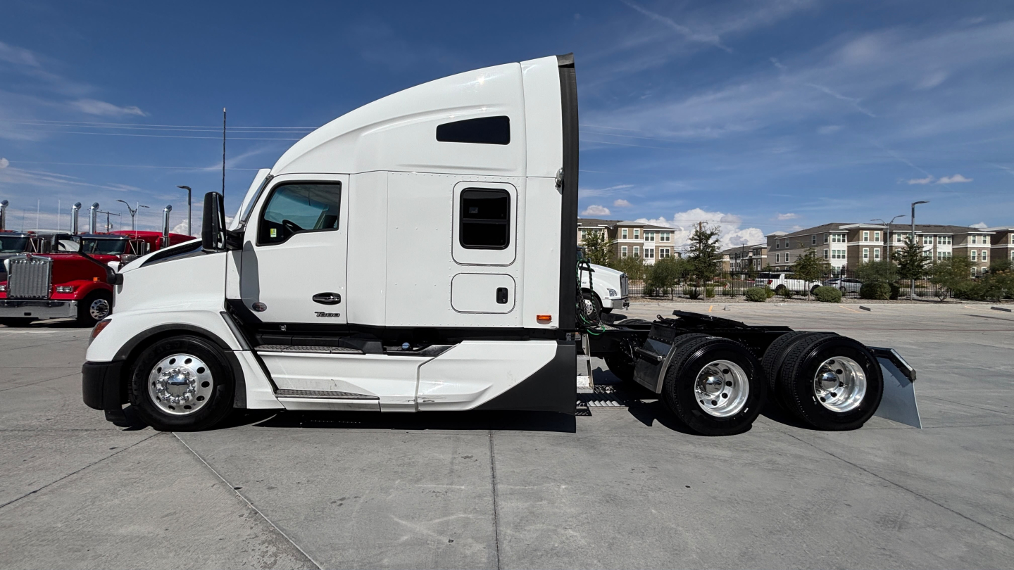 Truck side profile showing 2024 Kenworth T680 conventional sleeper, white exterior, sleeper cab, dual rear axles, chrome wheels.
