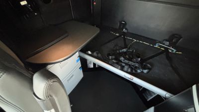 Kenworth T680 sleeper truck interior showing dashboard and under-seat storage with metal rod across cabin.