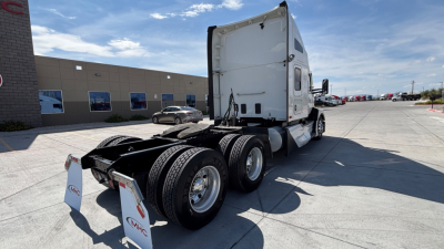 Kenworth T680 tractor in a lot showing rear view with dual rear axles and white sleeper cab.