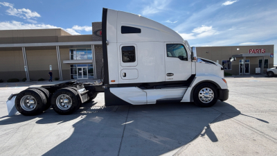 Kenworth T680 cab and chassis side profile with white exterior; visible wheels; dealership backdrop; no license plate visible.