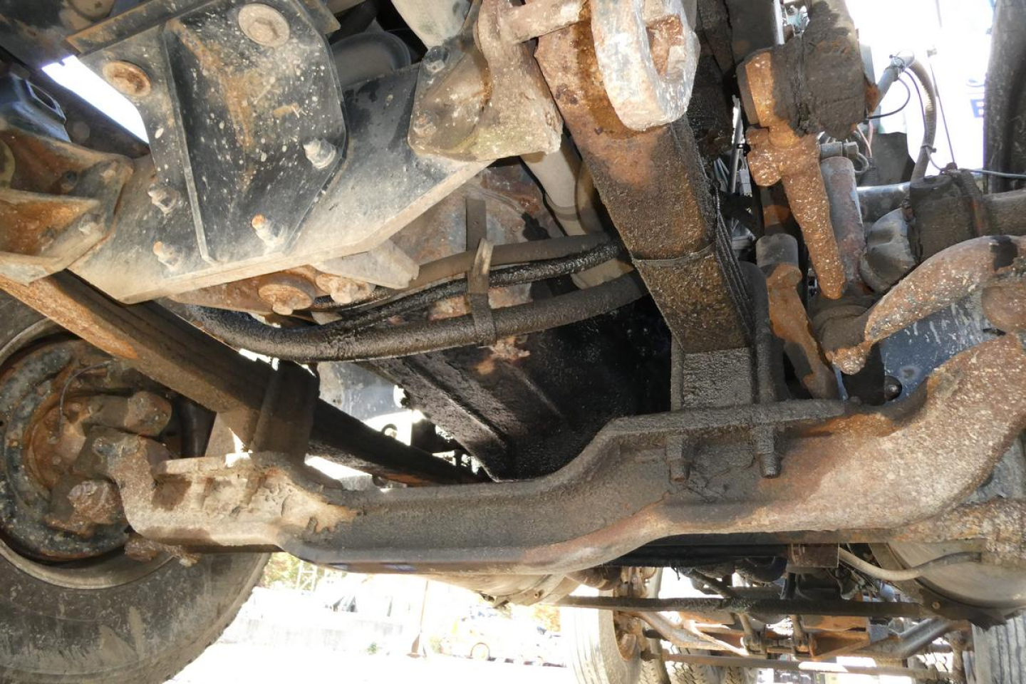 Underbody view of a 2001 Mack RD688S dump truck showing suspension and frame components with rust and hydraulic lines.