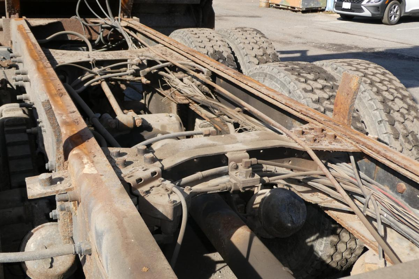Mack RD688S truck chassis underside showing frame rails, suspension, air lines, and dual rear tires with some surface rust and wiring harnesses.