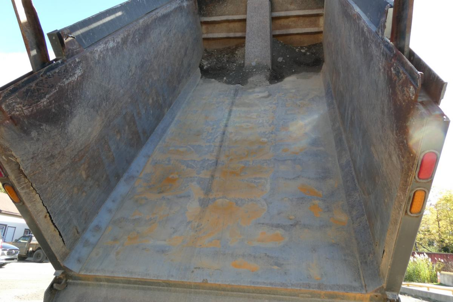 Dump truck bed of a 2001 Mack RD688S showing rust-stained steel cargo area with raised side walls and tailgate open.