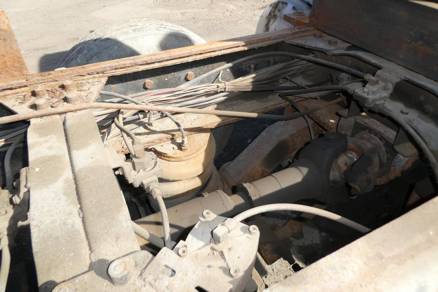 Under-hood view of a 2001 Mack RD688S dump truck showing engine bay with hoses, wiring, and components.