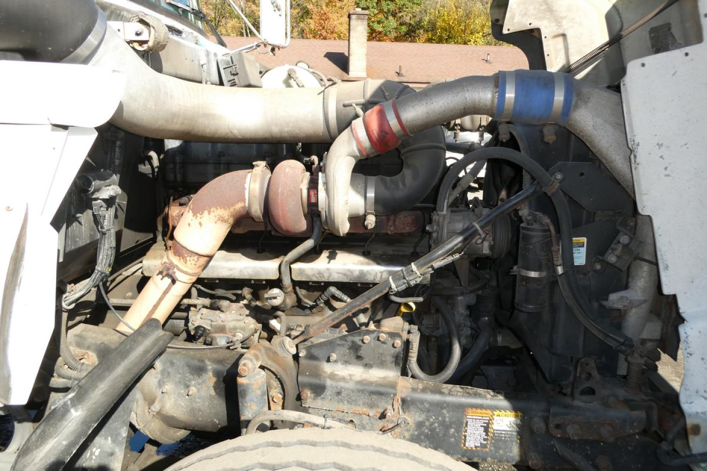 Mack RD688S engine bay showing turbocharger and exhaust manifold with hoses and components.