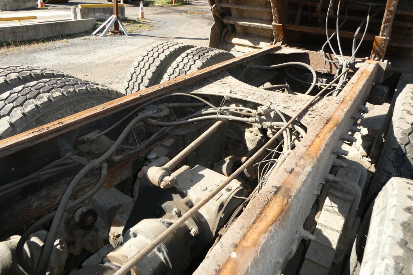 Mack RD688S truck chassis showing drivetrain and air lines with dual rear wheels and rusty frame.