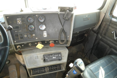 Dashboard of a 2001 Mack RD688S dump truck showing gauges, control panel, CB microphone, and gear selector.