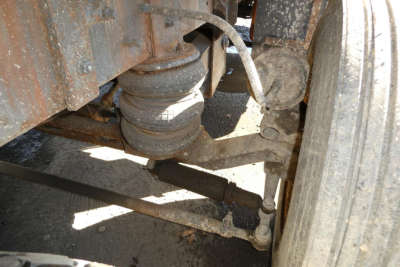 Mack RD688S truck undercarriage showing steering linkage and suspension components with dirt and grime.