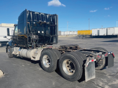 Truck tractor cab and rear chassis showing fifth wheel and dual rear axles.