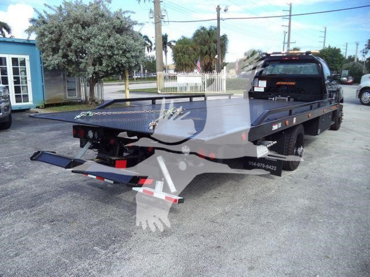 Flatbed rollback tow truck with rear loading ramps displayed, Chevrolet Silverado 6500HD title text visible on truck bed