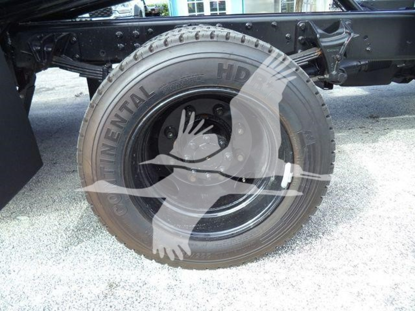 Rear wheel and tire of a Chevrolet Silverado 6500HD rollback truck showing Continental tire and black steel wheel with suspension and frame components.