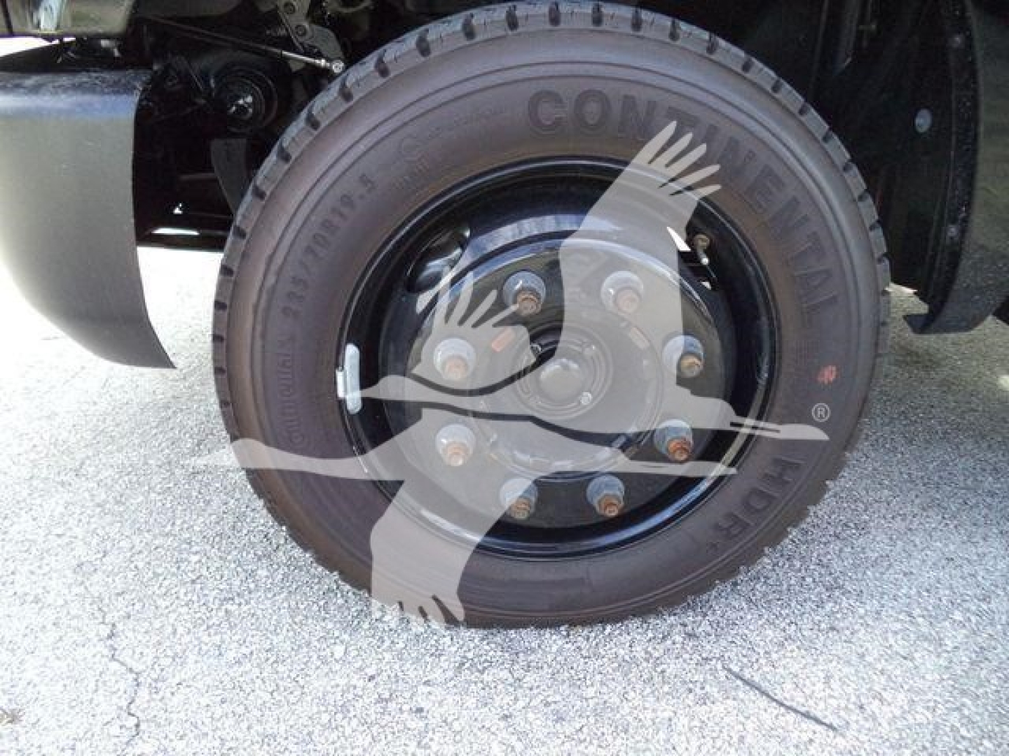 Truck wheel showing Continental tire and wheel hub with lug nuts.