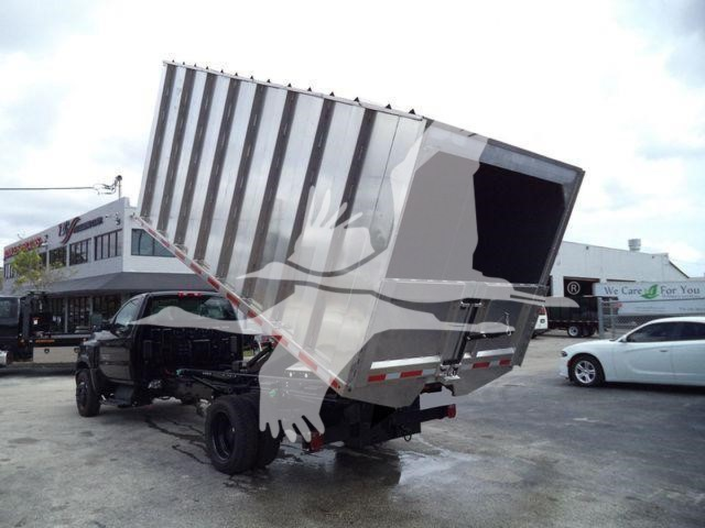 Truck chassis with a hydraulic dump bed raised, rear view showing dump trailer on a Chevrolet Silverado 6500HD chassis.