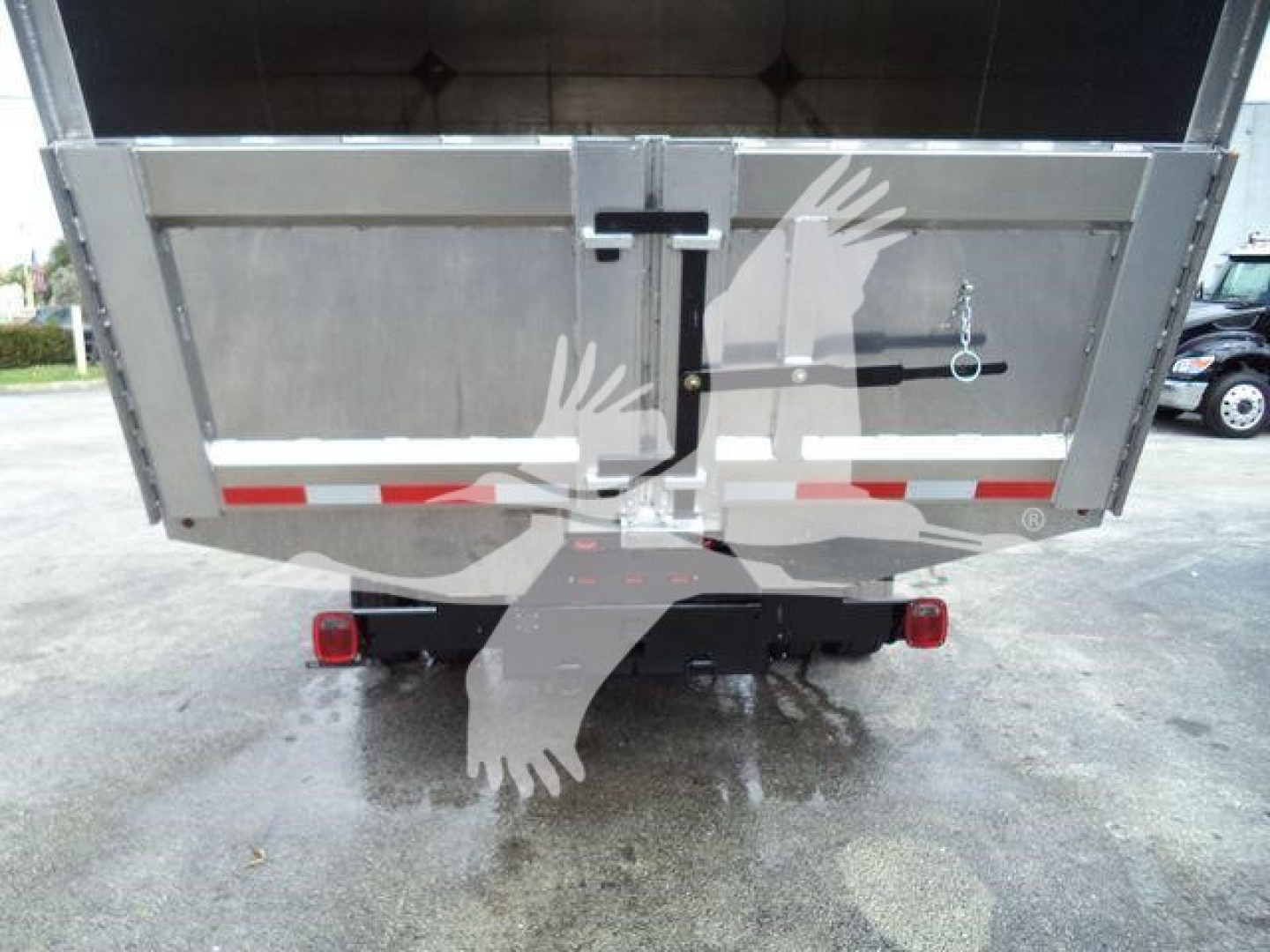 Chevrolet Silverado 6500HD dump bed viewed from rear showing tailgate latch and rear lights.