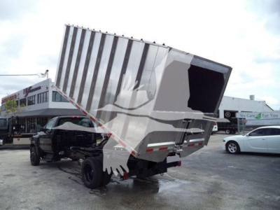 Truck chassis with a hydraulic dump bed raised, rear view showing dump trailer on a Chevrolet Silverado 6500HD chassis.