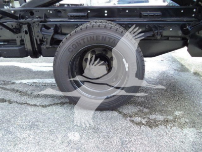 Truck chassis with rear wheel and suspension visible; Continental tire label on wheel.