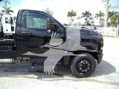 Chevrolet Silverado 6500HD cab showing side profile with chipper truck body and front wheel.
