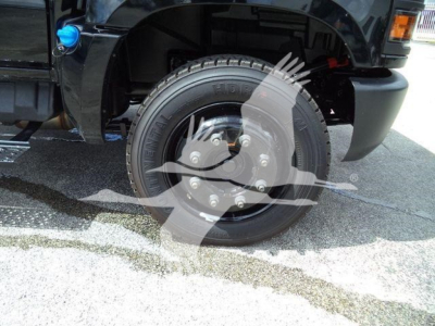 Front wheel and tire of a 2023 Chevrolet Silverado 6500HD with visible wheel hub caps and tire markings in a truck chassis photo.