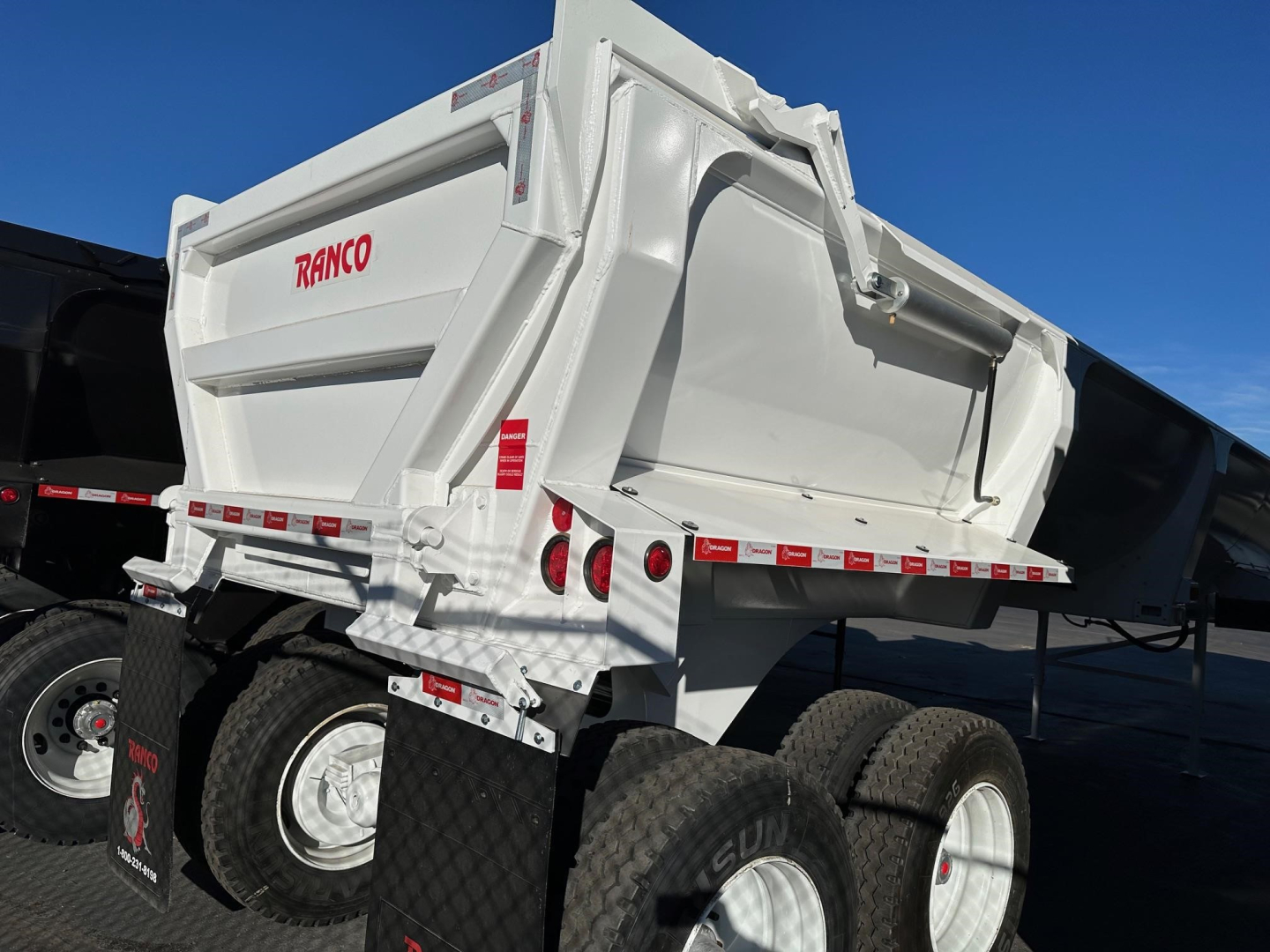 Ranco Ed26-34 dump trailer showing white steel dump body with red RANCO logo and dual rear taillights.