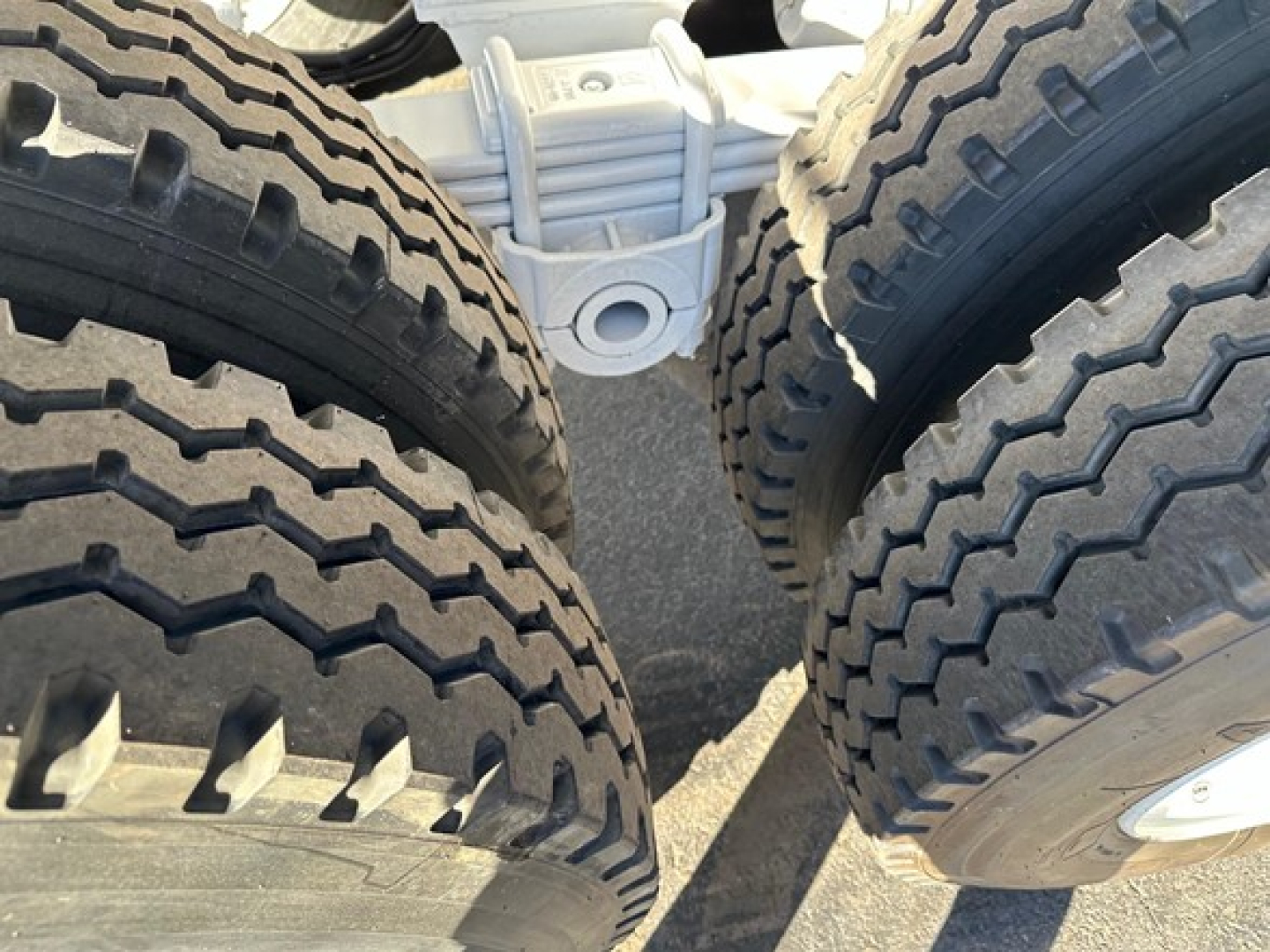 Dump trailer undercarriage showing dual rear wheels and suspension components.