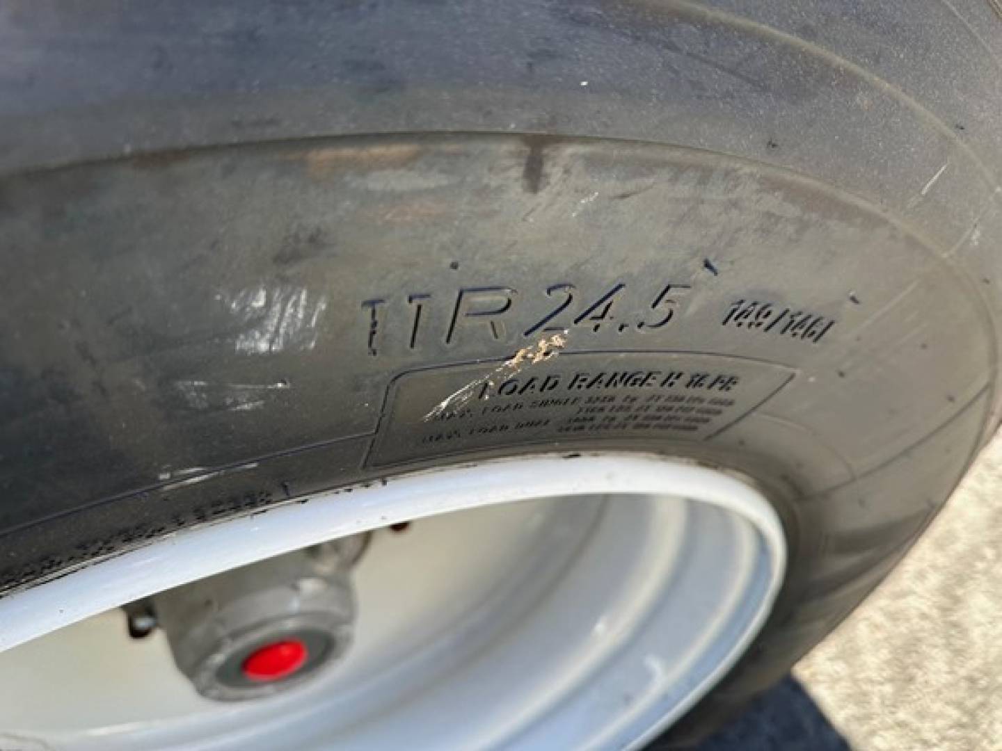 Tire with markings: 'TR 24.5' and other small text on sidewall near wheel, showing part of a trailer wheel/tire setup.