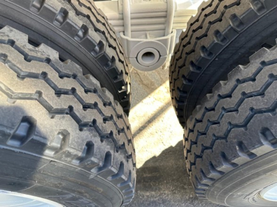 Trailer dual rear tires and suspension in view for 2027 Ranco Ed26-34 dump trailer showing dual tractor tires and frame.