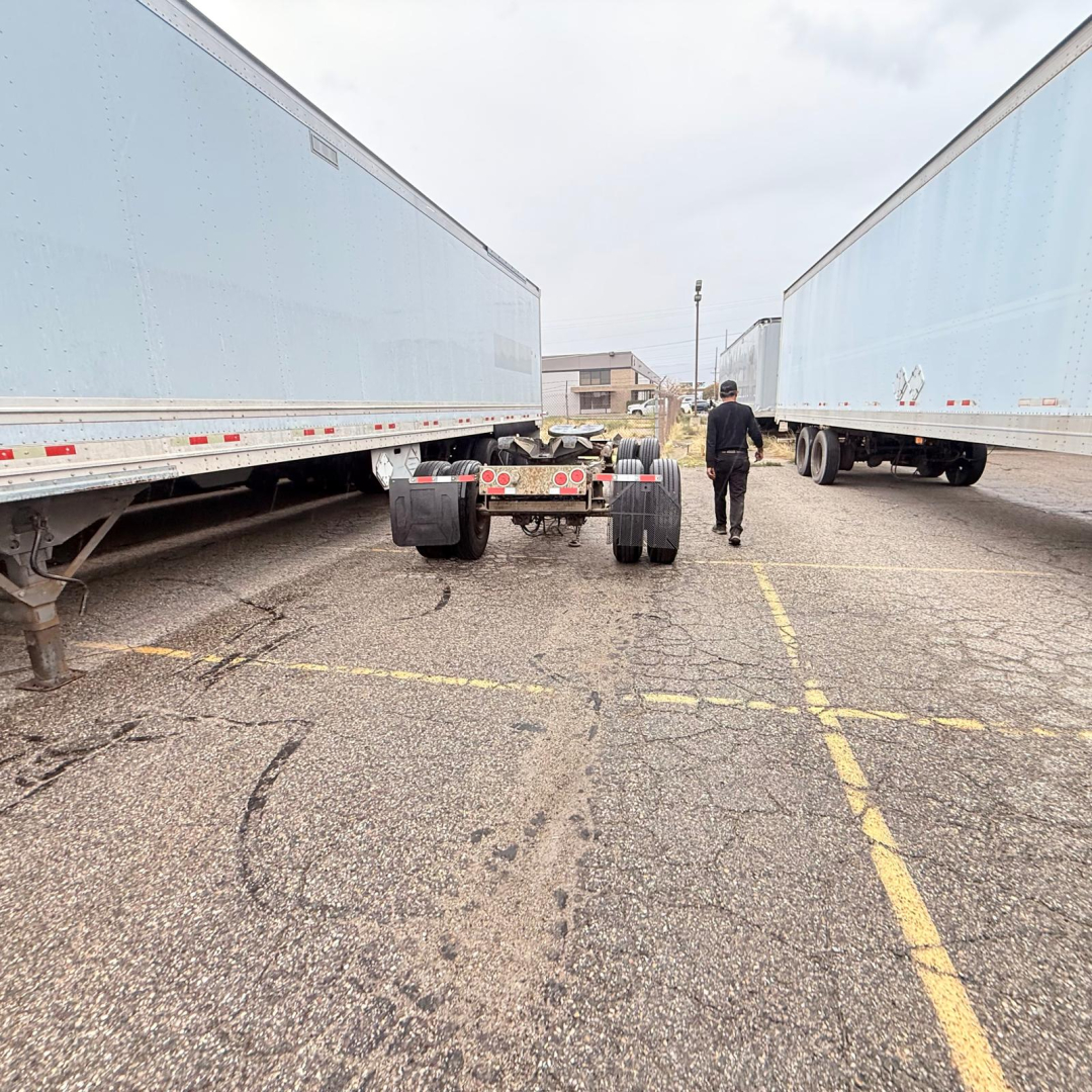 Trailer hitch between two light blue Great Dane 7441 SL dry van trailers in a parking lot.