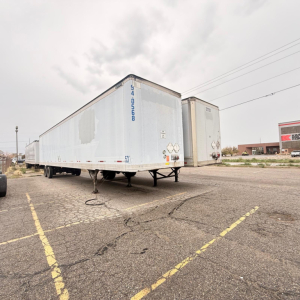 Great Dane dry van trailer in a lot, blue exterior with serial/ID numbers on front corner and reflective markings visible.