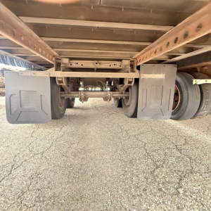 Underbelly view of a Great Dane dry van trailer showing dual rear wheels and undercarriage components with mud flaps on both sides.