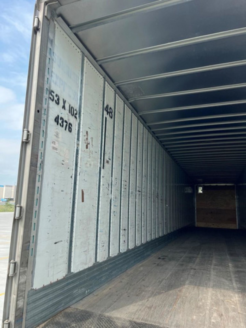 Trailer interior showing metal walls with numbered markings and ribbed ceiling; empty cargo area in a used 2014 utility van trailer.