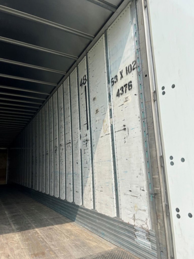 Trailer interior side wall with vertical ribs and stamped numbers: 8? 3 X 102 and 4376 visible along the metal panel.
