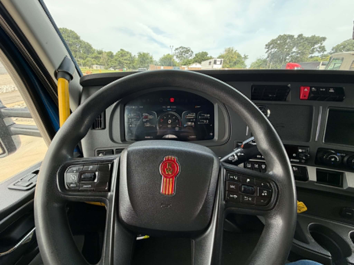 Kenworth T680 truck interior steering wheel and dashboard view showing instrument cluster and steering controls.