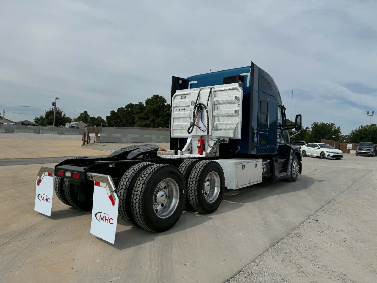 Kenworth T680 tractor rear view showing dual rear axles and fuel/air lines with service box mounted behind cab.