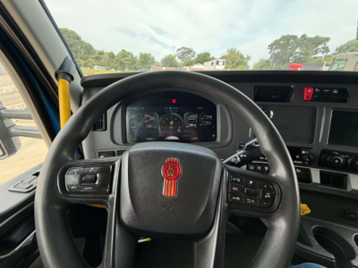 Kenworth T680 truck interior steering wheel and dashboard view showing instrument cluster and steering controls.