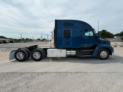 Kenworth T680 tractor side view showing 6x4 configuration, blue cab, aluminum fuel tanks, and sleeper cab with dual rear axles.