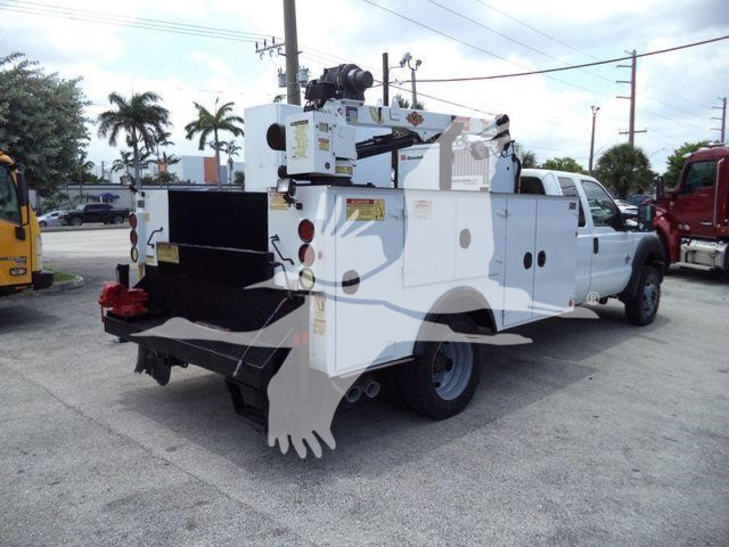 Ford F-450 utility service truck with crane/boom attached, side compartments, rear platform, white body, visible utility equipment.