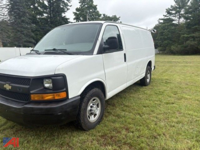 Chevrolet Express 2500 cargo van in white, front view with black bumper and headlights, parked on grass.