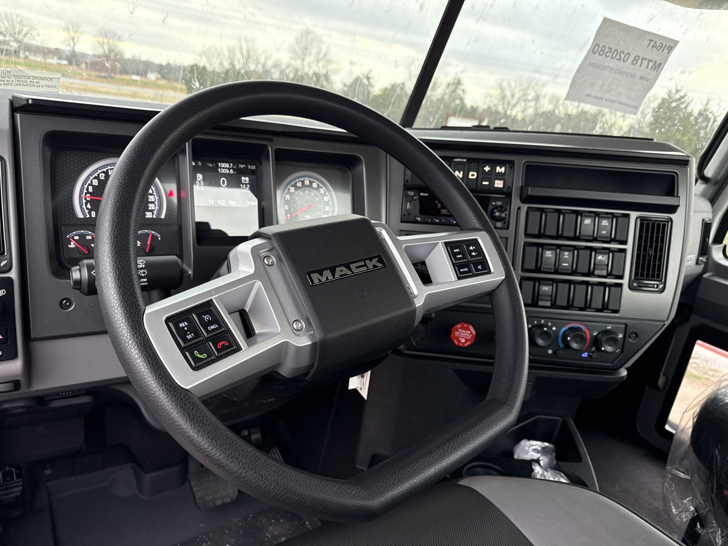 Mack PI64T dash and steering wheel in-cab view showing dashboard gauges and controls.