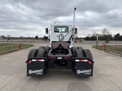 Mack PI64T cab and drivetrain rear view showing dual rear axles and toolbox mudflaps with Bruchner's branding.