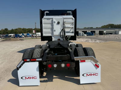 Kenworth T680 rear view showing chassis and suspension with MHC branded mud flaps.