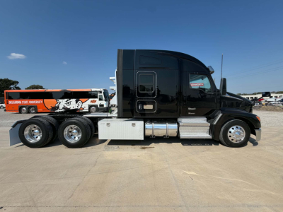 Kenworth T680 tractor in profile view showing sleeper cab, black paint, chrome fuel tanks, side steps, and dual rear axles.