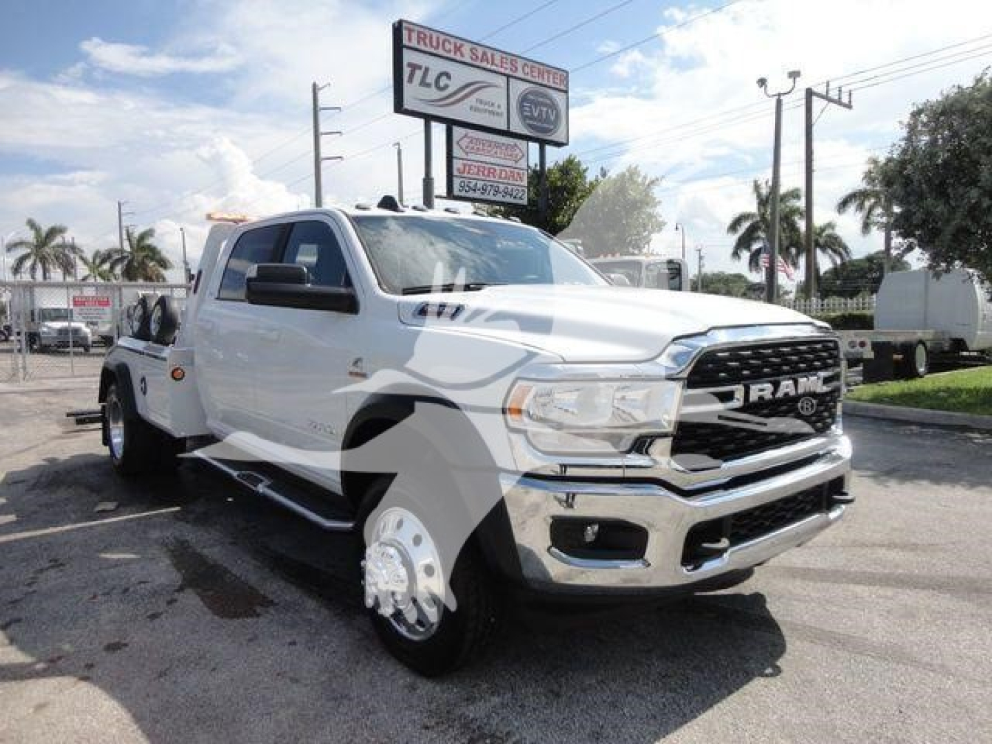 2024 Ram 5500 SLT pickup truck in a dealership lot, white exterior, front grille with RAM emblem, dual rear wheels visible, signboard above.