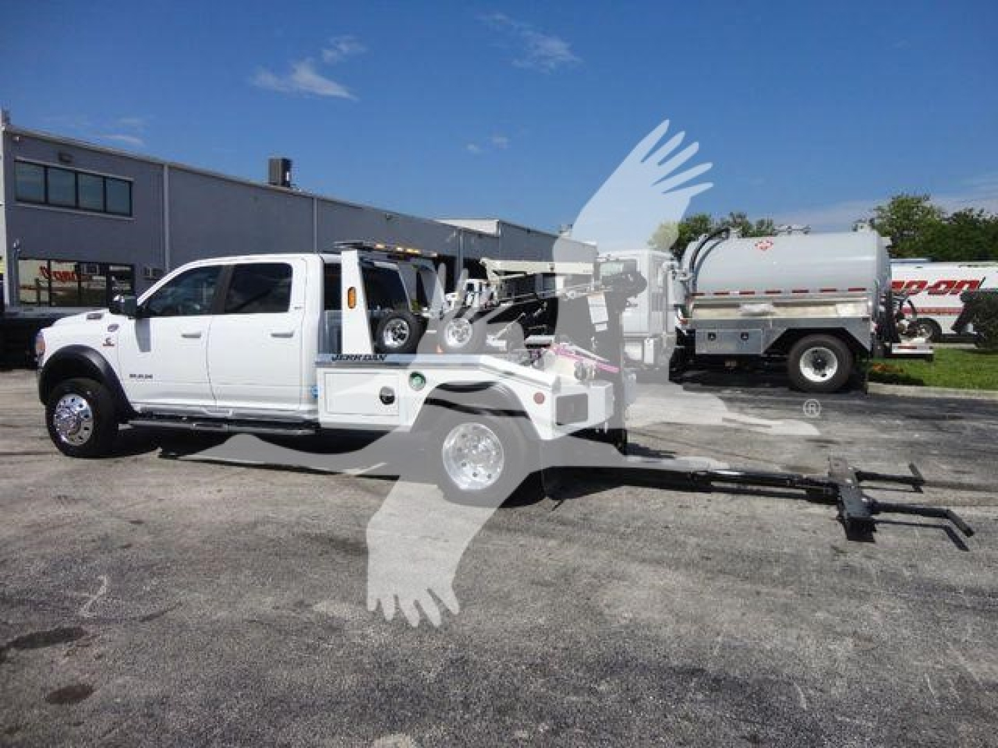 Truck with winch and trailer hitch showing Ram 5500 SLT branding, extended hitch apparatus and winch equipment attached to rear.