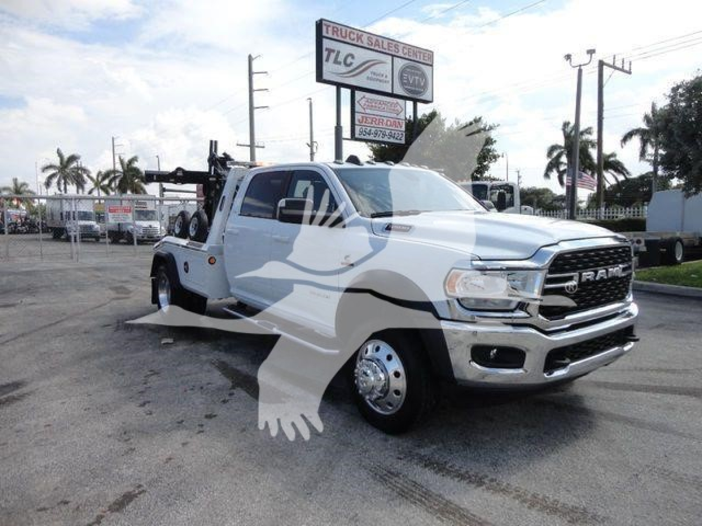 Ram 5500 truck in showroom lot showing front grille with RAM badge and dual rear wheel setup, white color, tow hoist and winch equipment visible.