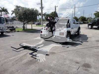 Ram 5500 tow truck with heavy-duty winch and recovery ramps in front, stock number J63987.