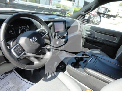 Ram 5500 interior showing steering wheel, dashboard, center touchscreen, and console with cupholders.